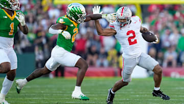Ohio State Buckeyes wide receiver Emeka Egbuka (2) runs [ast Oregon Ducks linebacker Jeffrey Bassa (2) and defensive end Jordan Burch (1) during the first half of the College Football Playoff quarterfinal at the Rose Bowl in Pasadena, Calif. on Jan. 1, 2025.