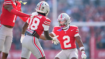 Ohio State Buckeyes cornerback Davison Igbinosun (1) and defensive back Caleb Downs (2) celebrate with safety Jaylen McClain (18) during the first half of the NCAA football game against the Rutgers Scarlet Knights at Ohio Stadium in Columbus on Nov. 22, 2025.