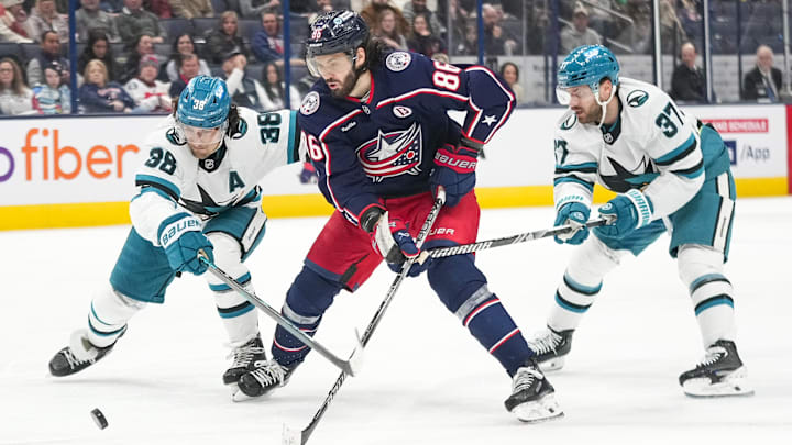 Jan 16, 2025; Columbus, Ohio, USA; Columbus Blue Jackets right wing Kirill Marchenko (86) shoots the puck against San Jose Sharks defenseman Mario Ferraro (38) and defenseman Timothy Liljegren (37) in the third period at Nationwide Arena on Thursday, Jan. 16, 2025 in Columbus, Ohio.   Mandatory Credit: Samantha Madar/USA TODAY Network via Imagn Images 