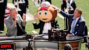 Lee Corso puts on the Brutus helmet as he makes his final pick between Kirk Herbstreit and Pat McAfee.