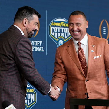 Ohio State Buckeyes head coach Ryan Day and Texas Longhorns head coach Steve Sarkisian shake hands following a press conference at AT&T Stadium prior to the College Football Playoff semifinal at the Cotton Bowl Classic in Arlington, Texas on Jan. 9, 2025.