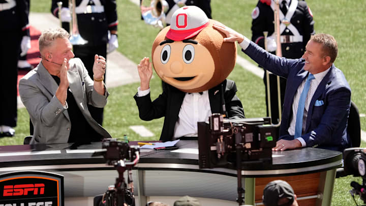 Lee Corso puts on the Brutus helmet as he makes his final pick between Kirk Herbstreit and Pat McAfee.