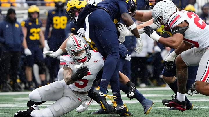Ohio State Buckeyes cornerback Aaron Scott Jr. (5) tackles Michigan Wolverines wide receiver Andrew Marsh (4) during the NCAA football game at Michigan Stadium in Ann Arbor, Mich. on Nov. 29, 2025. Ohio State won 27-9.