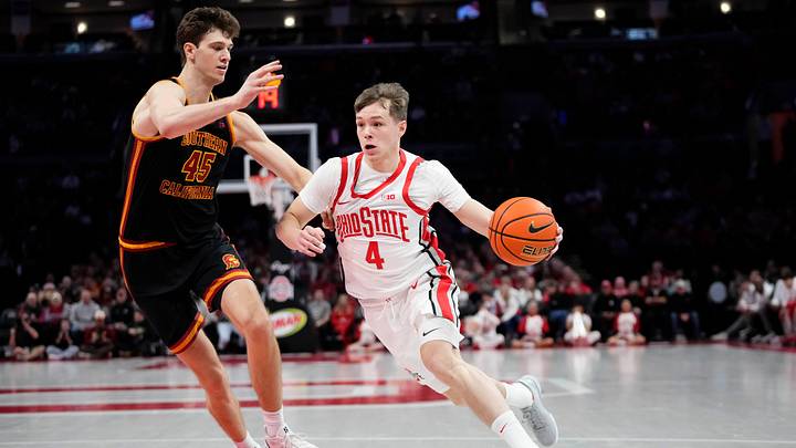 Ohio State Buckeyes guard Gabe Cupps (4) dribbles past USC Trojans center Gabe Dynes (45) during the first half of the NCAA men's basketball game at the Schottenstein Center on Feb. 11, 2026.