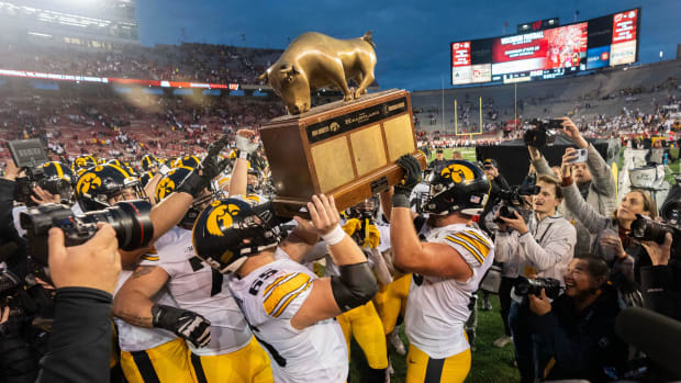 Iowa players hoist The Heartland Trophy after their game at Camp Randall Stadium.
