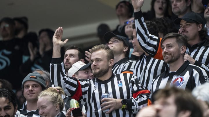 Apr 11, 2024; Seattle, Washington, USA; Fans dressed as referees cheer during the first period between the San Jose Sharks and the Seattle Kraken at Climate Pledge Arena. Mandatory Credit: Stephen Brashear-USA TODAY Sports