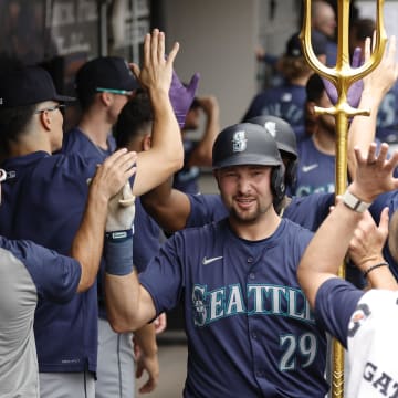 Seattle Mariners catcher Cal Raleigh celebrates with teammates in the dugout after hitting a two-run home run against the Chicago White Sox at Guaranteed Rate Field.