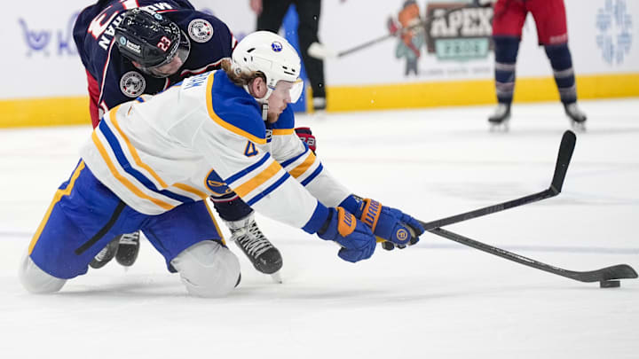 Oct 17, 2024; Columbus, Ohio, USA; Buffalo Sabres defenseman Bowen Byram (4) fights for the puck against Columbus Blue Jackets center Sean Monahan (23) in the third period at Nationwide Arena on Thursday. Mandatory Credit: Samantha Madar/USA TODAY Network via Imagn Images