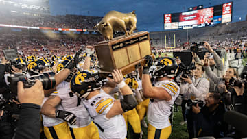 Oct 14, 2023; Madison, Wisconsin, USA; Iowa Hawkeyes players hoist The Heartland Trophy after defeating the Wisconsin Badgers at Camp Randall Stadium. Mandatory Credit: Mark Hoffman-Imagn Images