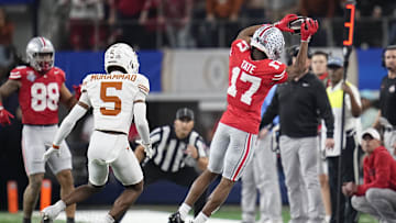 Ohio State Buckeyes WR Carnell Tate catches near Texas Longhorns corner Malik Muhammad during the College Football Playoff