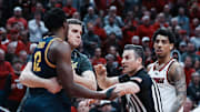 Cal head coach Mark Madsen held back Mady Sissoko after Sissoko was tripped by Louisville guard Terrence Edwards Jr. (right)