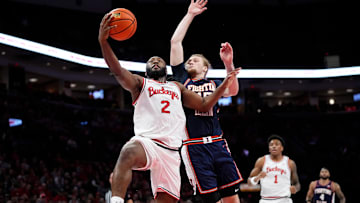 Ohio State Buckeyes guard Bruce Thornton (2) makes a layup in front of Illinois Fighting Illini forward Jake Davis (15) during the first half of the NCAA men's basketball game in Columbus on Dec. 9, 2025.