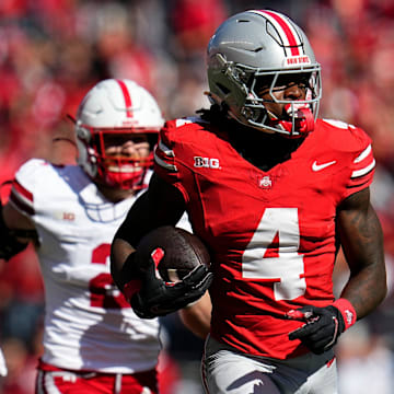 Ohio State Buckeyes wide receiver Jeremiah Smith (4) catches a touchdown pass in front of Nebraska Cornhuskers defensive back Isaac Gifford (2) during the first half of the NCAA football game at Ohio Stadium in Columbus on Saturday, Oct. 26, 2024.