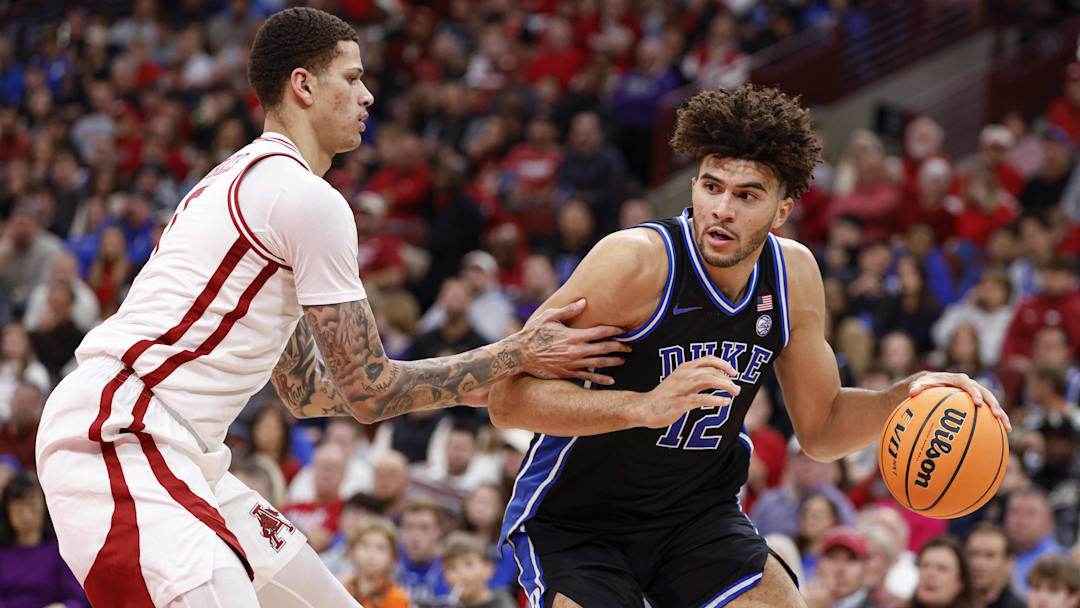 Nov 27, 2025; Chicago, Illinois, USA; Duke Blue Devils forward Cameron Boozer (12) drives to the basket against Arkansas Razorbacks forward Trevon Brazile (7) during the second half at United Center. Mandatory Credit: Kamil Krzaczynski-Imagn Images
