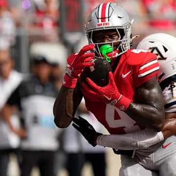 Aug 31, 2024; Columbus, OH, USA; Ohio State Buckeyes wide receiver Jeremiah Smith (4) catches his second touchdown pass of the first half in front of Akron Zips cornerback Devonte Golden-Nelson (3) during the NCAA football game at Ohio Stadium.