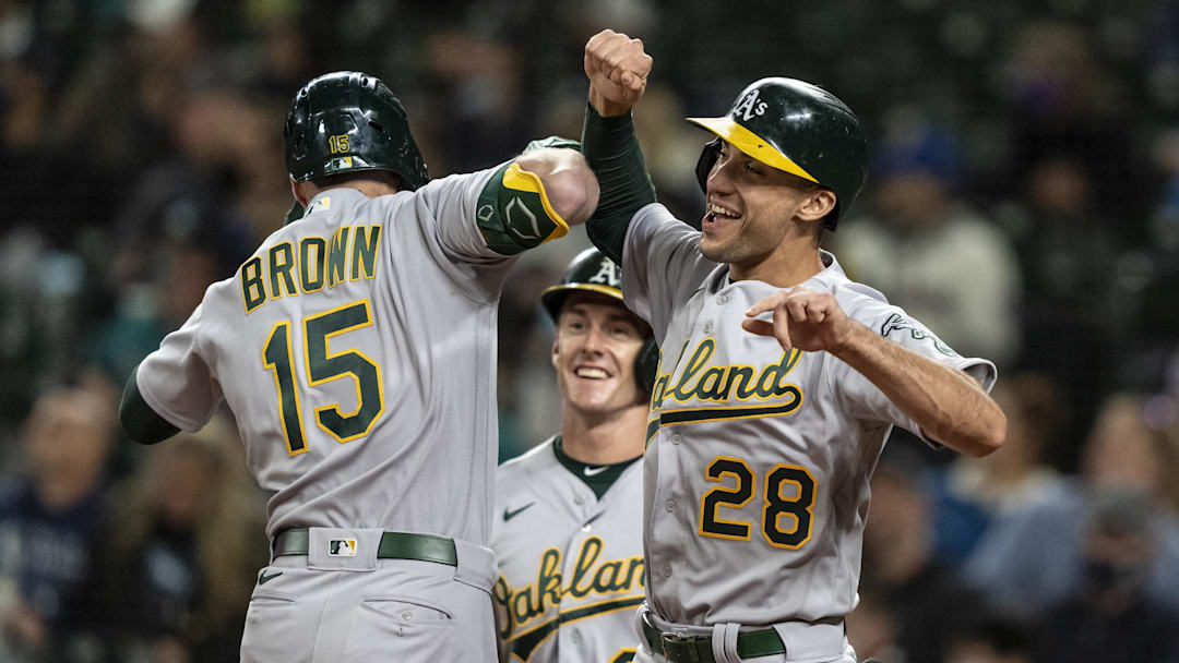 Sep 27, 2021; Seattle, Washington, USA;  Oakland Athletics centerfielder Seth Brown (15) celebrates with first baseman Matt Olson (28) and left fielder Mark Canha (20) after hitting a three run home run against the Seattle Mariners during the first inning at T-Mobile Park. Mandatory Credit: Stephen Brashear-Imagn Images