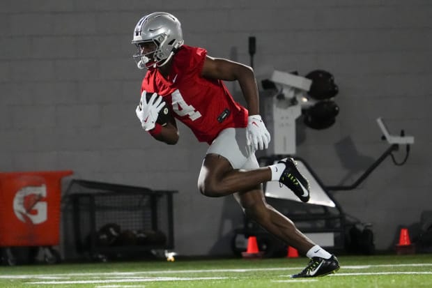 Wide receiver runs with ball in practice.