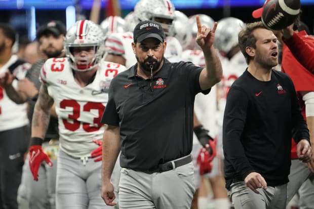 Head coach leads team out for game.