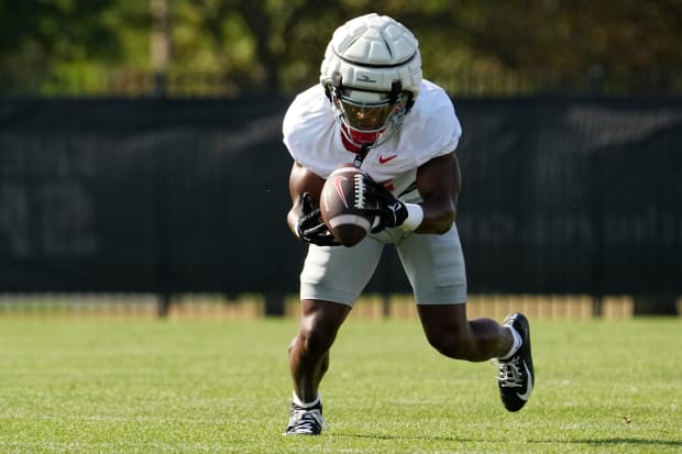 Safety picks up football in practice.