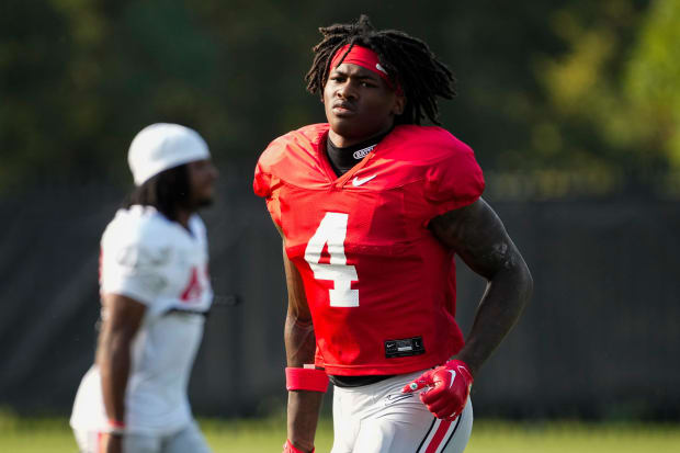 Receiver runs with helmet off during practice.