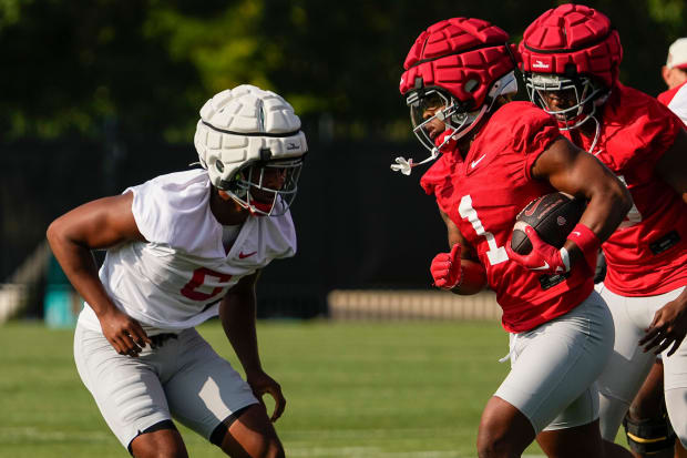 Running back carries football during practice.