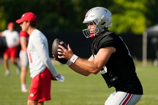 Quarterback takes snap in practice.