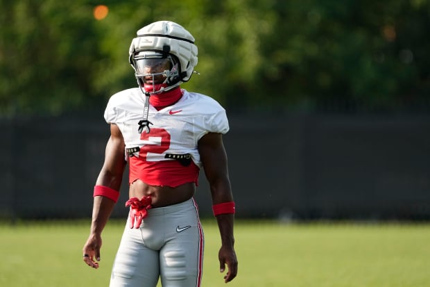 Football player stands and waits during drill.