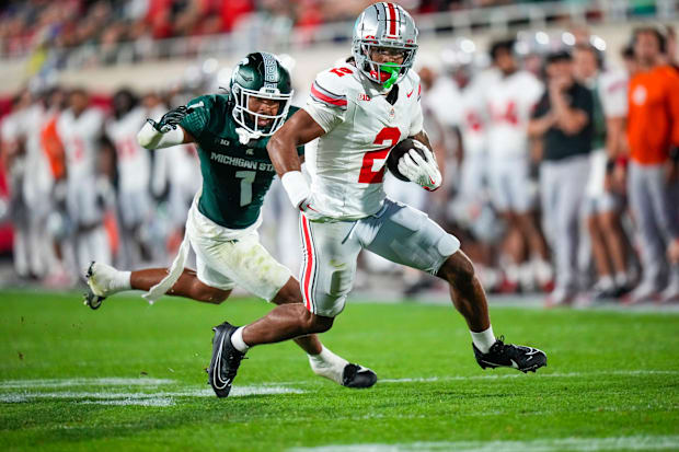 Wide receiver runs with football after catch.