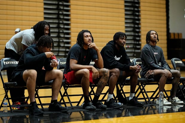 Basketball players watching game on the bench.