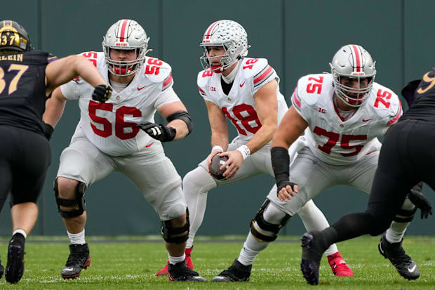 Ohio State Buckeyes quarterback Will Howard takes a snap behind offensive lineman Seth McLaughlin
