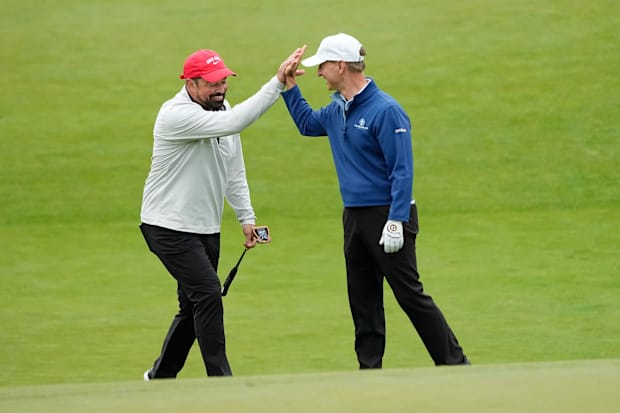 Ohio State football head coach Ryan Day gets a high five from Lee Styslinger after his putt on 18 during the Workday Golden B