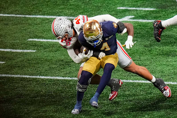 Ohio State Buckeyes defensive end JT Tuimoloau tackles Notre Dame Fighting Irish running back Jeremiyah Love.