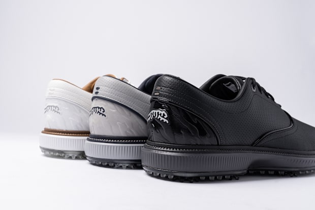 Tiger Woods' white, grey, and black golf shoes.