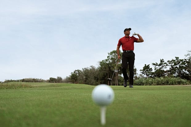 Tiger Woods models apparel on a golf course.