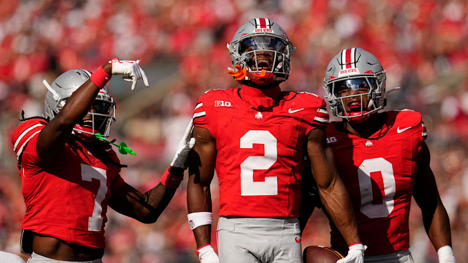 Ohio State safety Caleb Downs celebrates an interception with Jermaine Mathews Jr. and Sonny Styles.