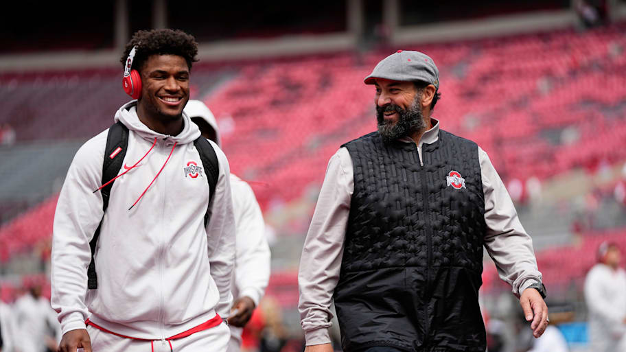 Ohio State safety Caleb Downs and defensive coordinator Matt Patricia walk across the field.