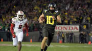 Jan 1, 2020; Pasadena, California, USA; Oregon Ducks quarterback Justin Herbert (10) runs against Wisconsin Badgers cornerback Rachad Wildgoose (5) in the fourth quarter during the 106th Rose Bowl game at Rose Bowl Stadium. Mandatory Credit: Kirby Lee-USA TODAY Sports