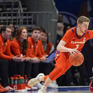 Mar 14, 2025; Charlotte, NC, USA; Clemson Tigers guard Jake Heidbreder (3) handles the ball against Louisville Cardinals guard Chucky Hepburn (24) during the second half at Spectrum Center. 