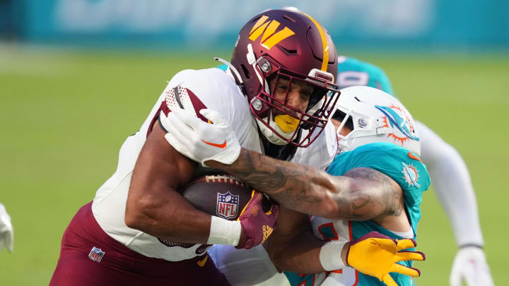 Aug 17, 2024; Miami Gardens, Florida, USA;  Washington Commanders running back Austin Ekeler (30) gains a few yards Miami Dolphins linebacker Curtis Bolton (58) closes in for the tackle during the first quarter at Hard Rock Stadium. Mandatory Credit: Jim Rassol-USA TODAY Sports