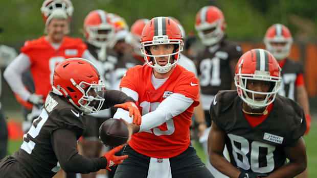 Cleveland Browns quarterback Joe Flacco makes a handoff to running back Dylan Sampson (22) during an NFL practice at the Clev