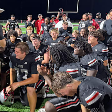 Lake Mary football coach Scott Perry, center standing, applauds his team after the Rams beat defending Class 7A state champ Venice, 31-26, in a state semifinal on Friday, Dec. 5.