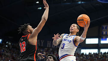 Nov 15, 2025; Lawrence, Kansas, USA; Kansas Jayhawks guard Tre White (3) shoots against Princeton Tigers forward Jacob Huggins (12) and forward Malik Abdullahi (7) during the second half at Allen Fieldhouse. Mandatory Credit: Jay Biggerstaff-Imagn Images