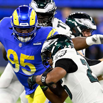 Nov 24, 2024; Inglewood, California, USA;  Los Angeles Rams defensive tackle Bobby Brown III (95) tackles Philadelphia Eagles running back Saquon Barkley (26) during the first half at SoFi Stadium. Mandatory Credit: Alex Gallardo-Imagn Images