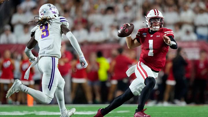 Sep 12, 2026; Madison, Wisconsin, USA;  Wisconsin Badgers quarterback Colton Joseph (1) looks to throw a pass under pressure from Western Illinois Leathernecks defensive back Aa'zoriyon Bonner (3) during the third quarter at Camp Randall Stadium. Mandatory Credit: Jeff Hanisch-Imagn Images