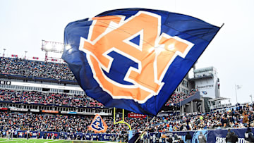 Dec 30, 2023; Nashville, TN, USA; An Auburn Tigers cheerleader waives a flag in the end zone after a touchdown during the first half against the Maryland Terrapins at Nissan Stadium. Mandatory Credit: Christopher Hanewinckel-Imagn Images