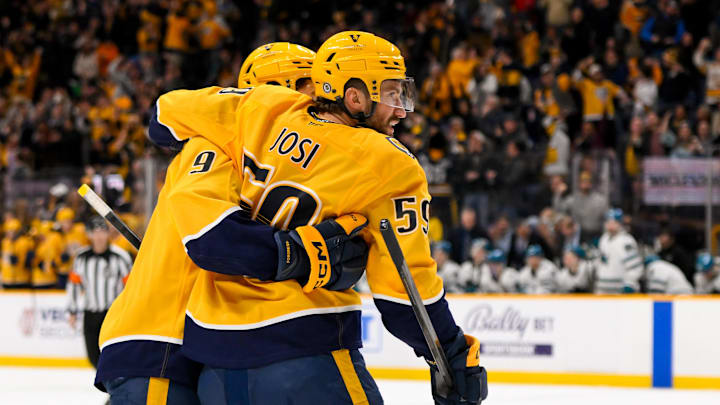 Jan 21, 2025; Nashville, Tennessee, USA;  Nashville Predators left wing Filip Forsberg (9) cebrates the goal of defenseman Roman Josi (59) against the San Jose Sharks during the third period at Bridgestone Arena. Mandatory Credit: Steve Roberts-Imagn Images