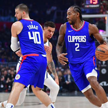  Los Angeles Clippers forward Kawhi Leonard (2) moves the ball as center Ivica Zubac (40) provides coverage against Denver Nuggets forward Michael Porter Jr. (1) during the first half at Crypto.com Arena. 