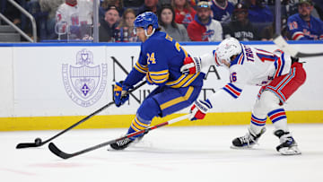 Feb 22, 2025; Buffalo, New York, USA;  Buffalo Sabres center Dylan Cozens (24) skates with the puck as New York Rangers center Vincent Trocheck (16) defends during the second period at KeyBank Center. Mandatory Credit: Timothy T. Ludwig-Imagn Images