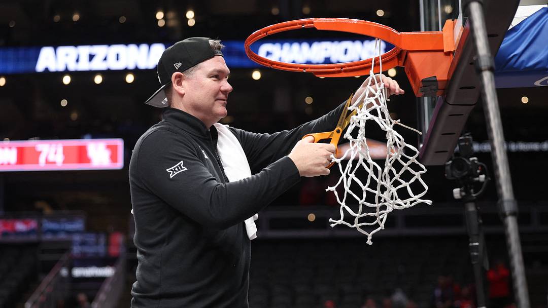 Mar 14, 2026; Kansas City, MO, USA; Arizona Wildcats head coach Tommy Lloyd cuts the net after a win over the Houston Cougars during the men's Big 12 Conference Tournament Championship at T-Mobile Center.