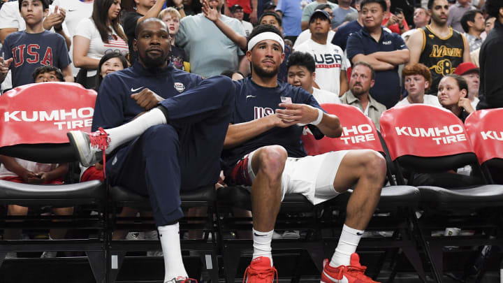 Jul 10, 2024; Las Vegas, Nevada, USA; USA forward Kevin Durant (7) and guard Devin Booker (15) look on from the bench during the fourth quarter against Canada in the USA Basketball Showcase at T-Mobile Arena. Mandatory Credit: Candice Ward-USA TODAY Sports